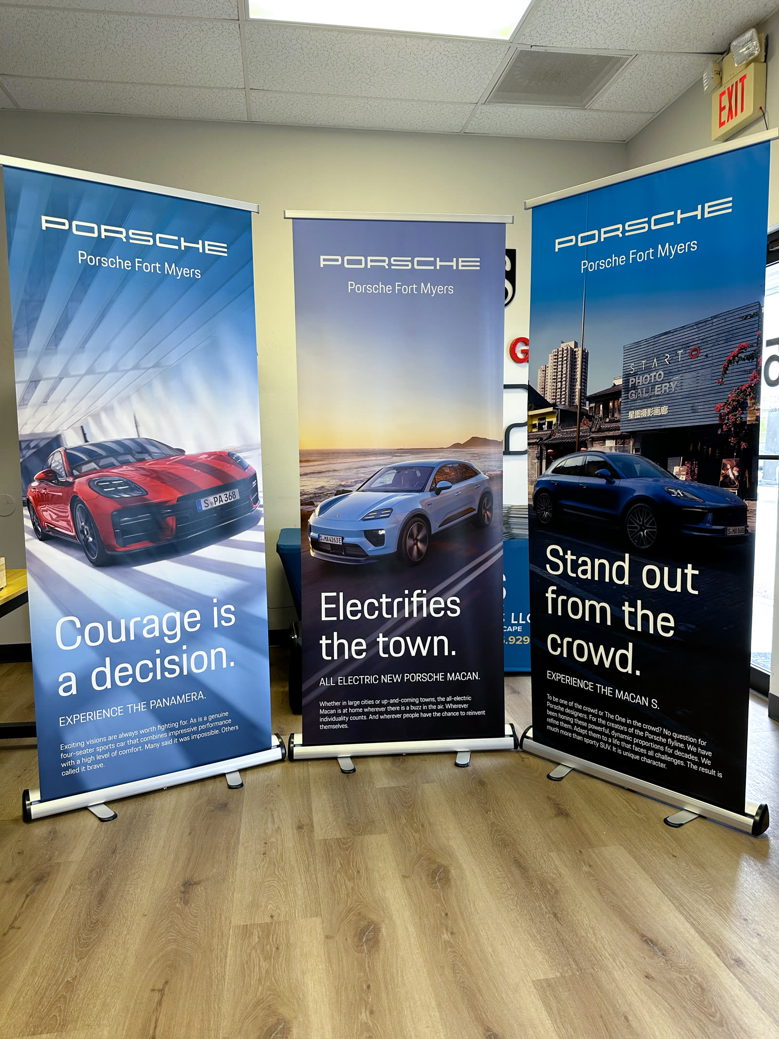 Three pull-up retractable banners printed for Porsche Fort Myers — Panamera, Macan EV and Macan S — manufactured at Brittoprint, Lehigh Acres FL